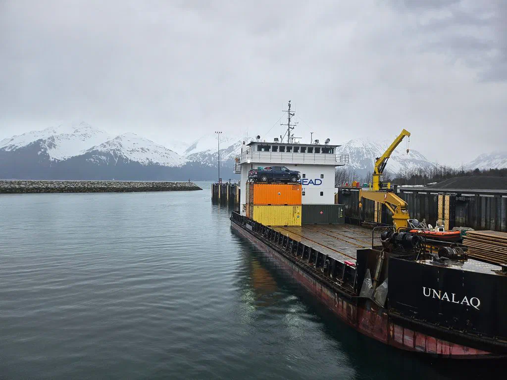 The cargo vessel Unalaq docked beneath snow-covered mountains