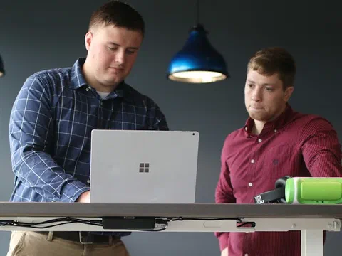 Two people reviewing survey data together on a laptop